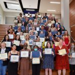 More than 50 students smiling with their award certificates and plaques after the 2022 College of Fine Arts Honors and Awards Ceremony