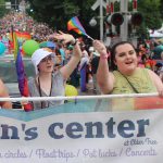Students from the UCO womens, gender and sexuality studies program walk the Northwest Arkansas Pride Parade in holding banner for the Elder Tree Women's Center