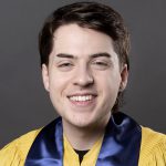 UCO Liberal Arts Fall 2022 Class Marshall Parker Tidwell wearing the ceremonial bronze graduation robe with blue stole.