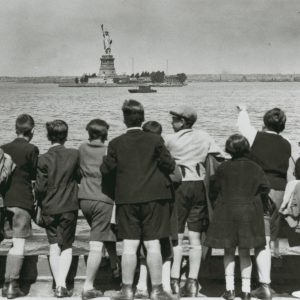 Jewish refugee children wave at the Statue of Liberty as the President Harding steams into New York harbor