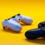 Two video game joysticks on yellow back ground