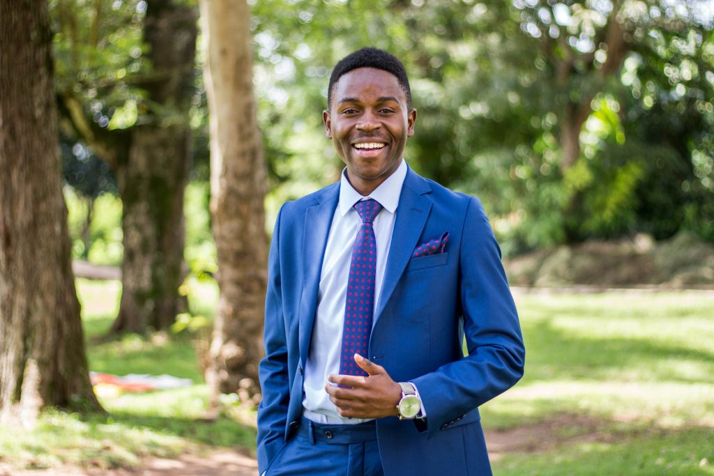 UCO MPA Student in suit smiles outside