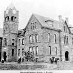 Old Black and white photo of UCO's clocktower "Old North" a couple horse back riders in front of the building. - when it was still called Oklahoma Normal School